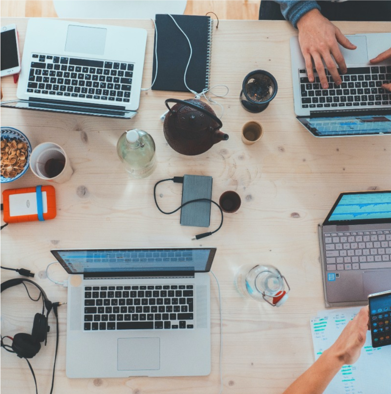 Multiple people in a team meeting at a cluttered desk