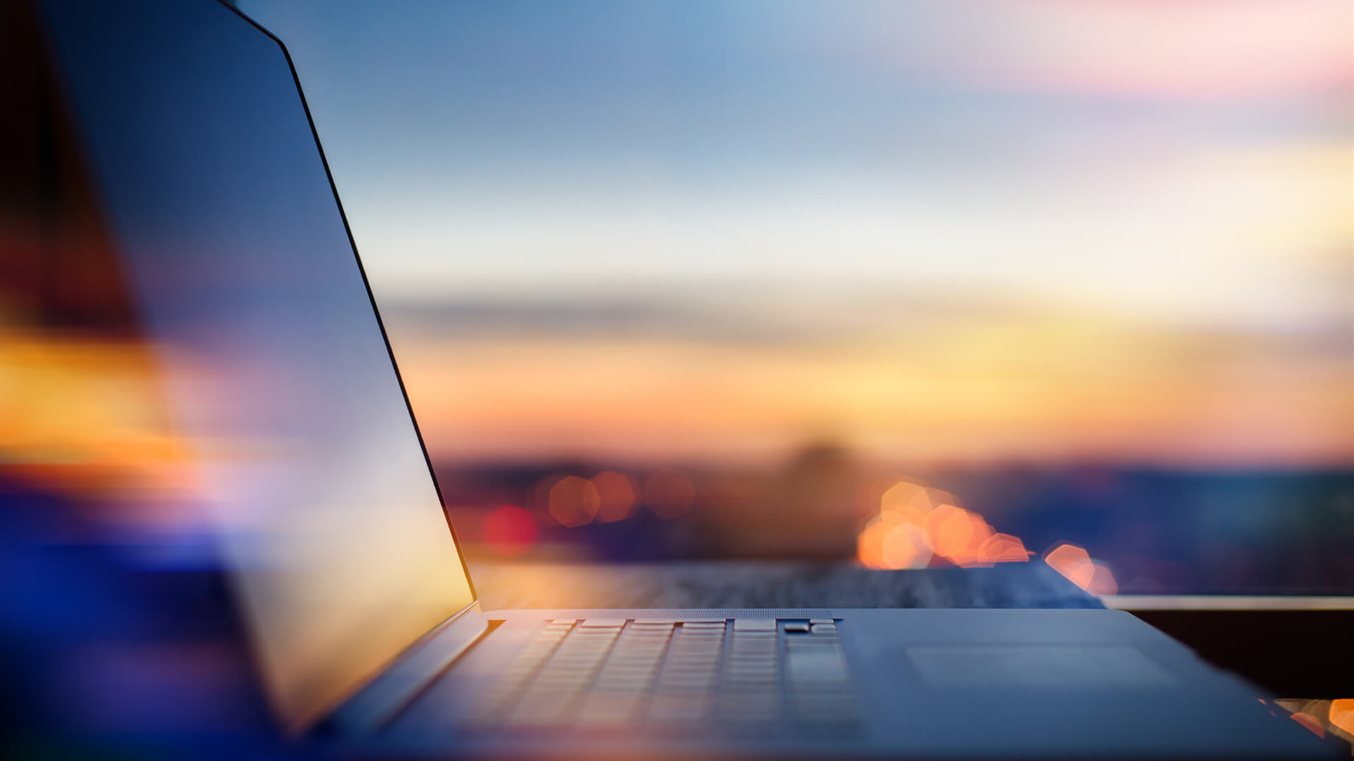 Close up of laptop against a sunset