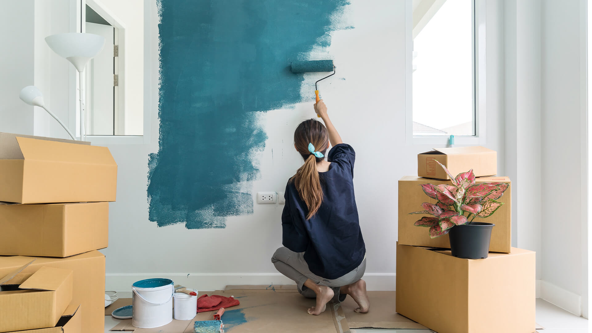 Woman painging her home interoir blue