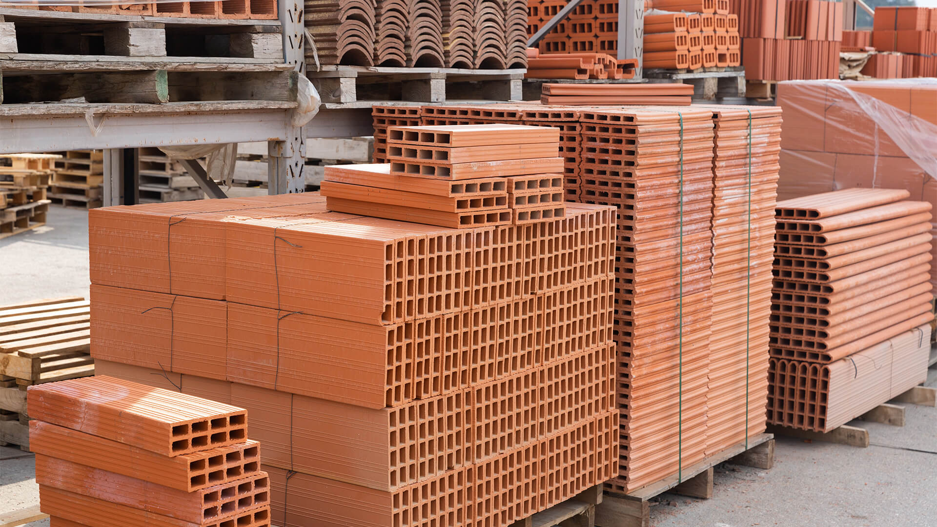 Piles of red brick building materials in a warehouse