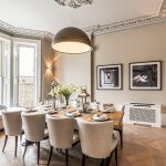 Modern Luxury Dining Room with a Large Hanging Lamp and big White Chairs