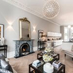 Luxury Living Room with a Dark Stone Fireplace and a Gold Mirror hanging above it