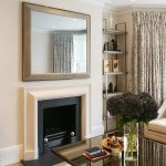 Modern Sitting room with Cream coloured walls and fireplace, a Coffee Table with Dark Coloured Plants on it