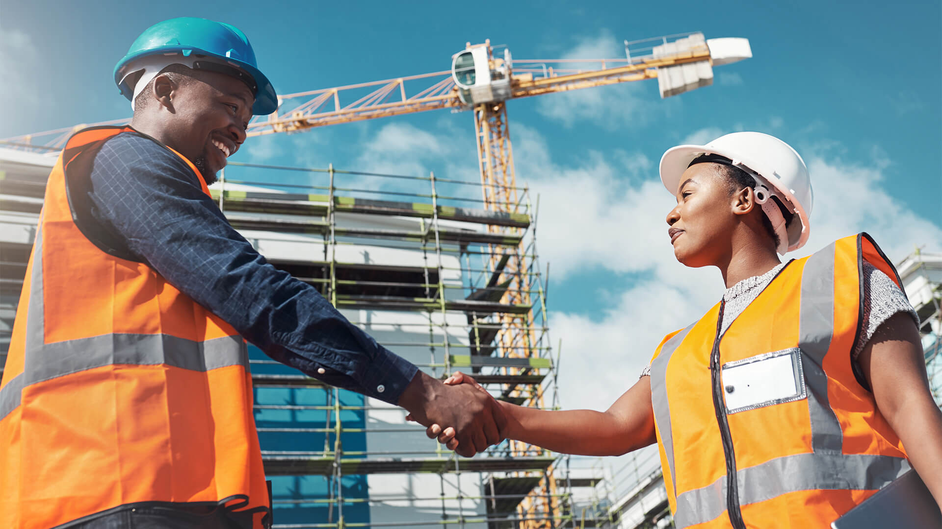 Shot of two builders shaking hands at a construction site.
