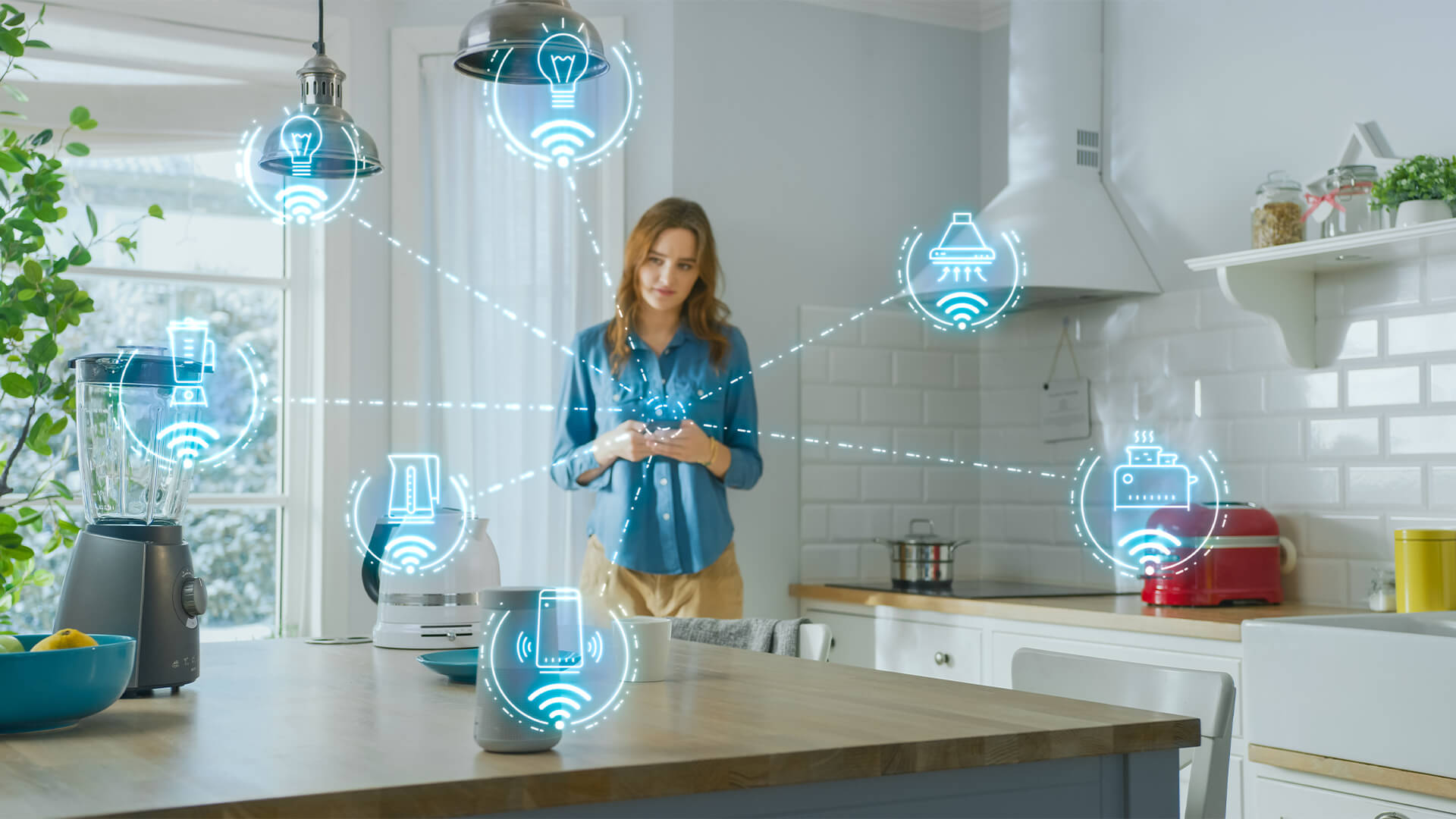 Young Woman Using Smartphone in Kitchen. She controls her Kitchen Appliances with IOT.